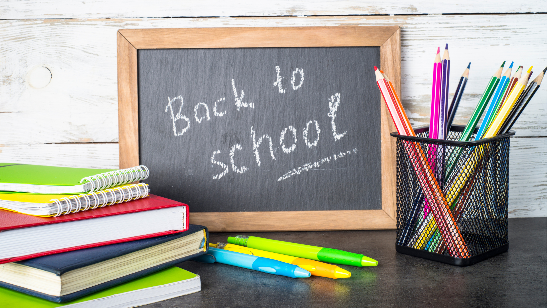 Chalkboard with words Back to School surrounded by books and colored pencils