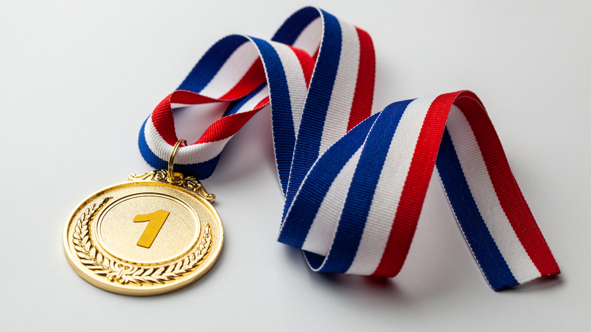 Gold Medal adorned with the number one on a red, white, and blue ribbon