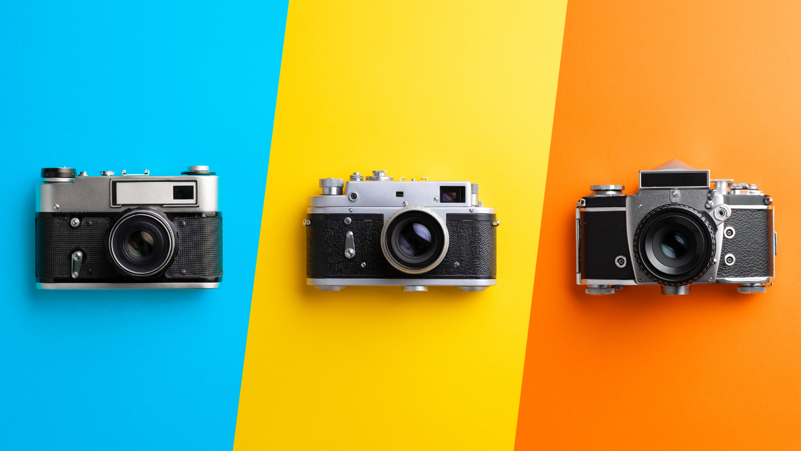 3 cameras on color blocked background of blue, yellow and red