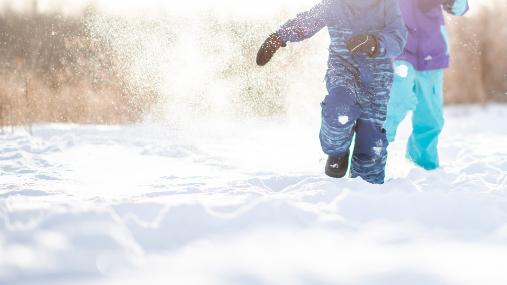 winter snow scene with two children running in snowsuits